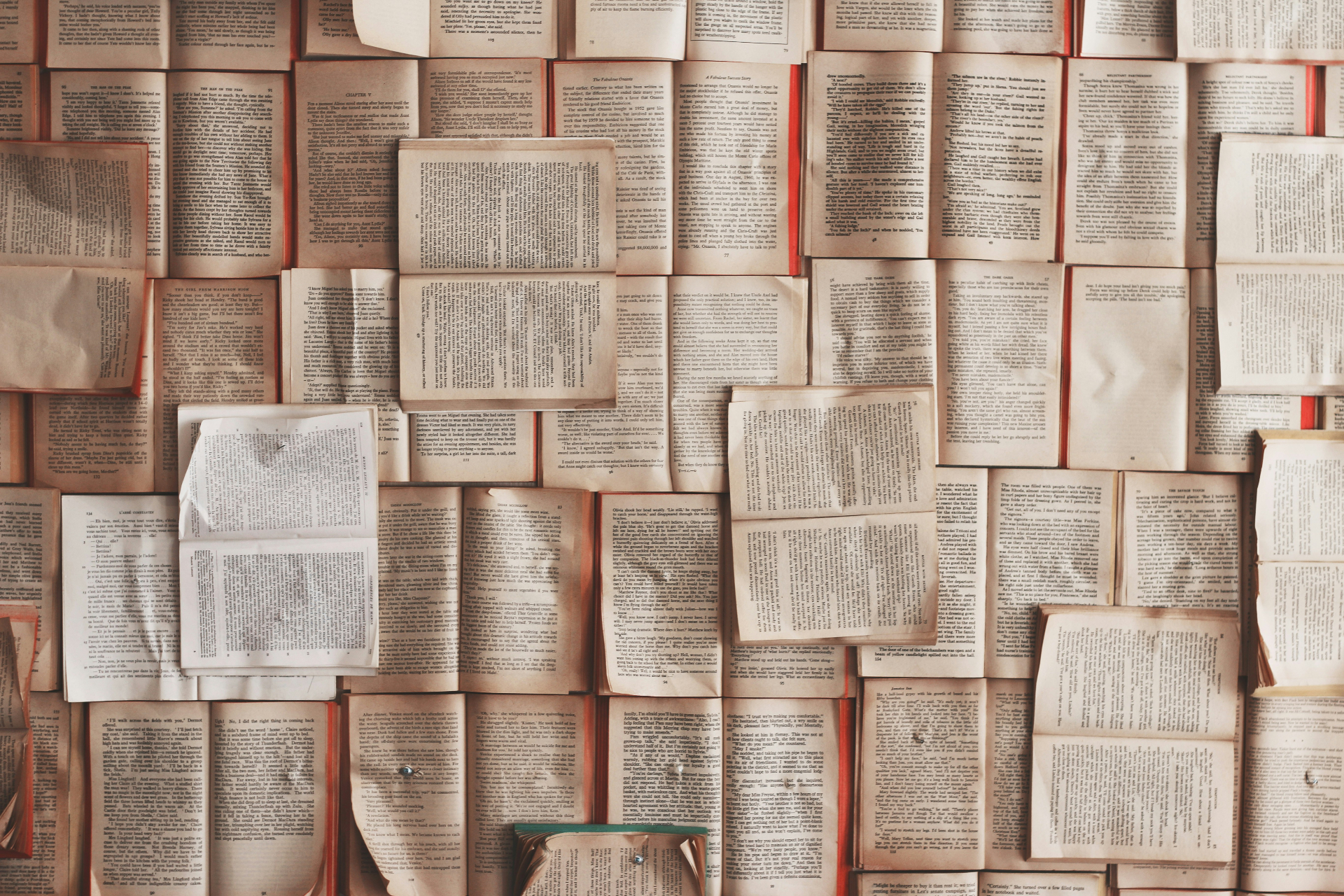 Wall of open books with visible pages, illustrating how to title an essay and choose strong essay titles for students